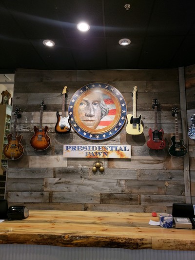 Presidential Pawn sign surrounded by electric guitars.